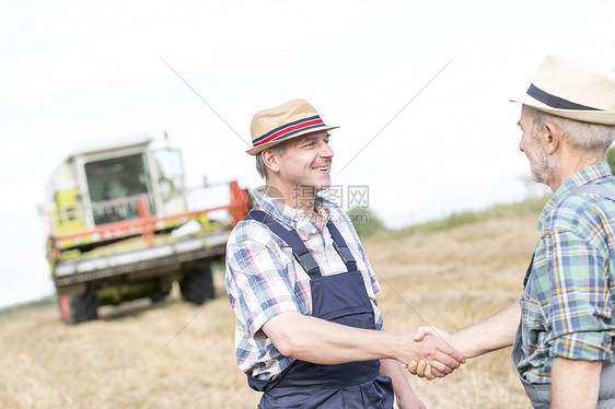 农民们农场站田里握手图片