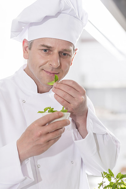 自信成熟的厨师餐厅餐厅厨房里的药草叶子图片