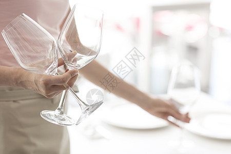 餐厅里年轻的女服务员着酒杯图片