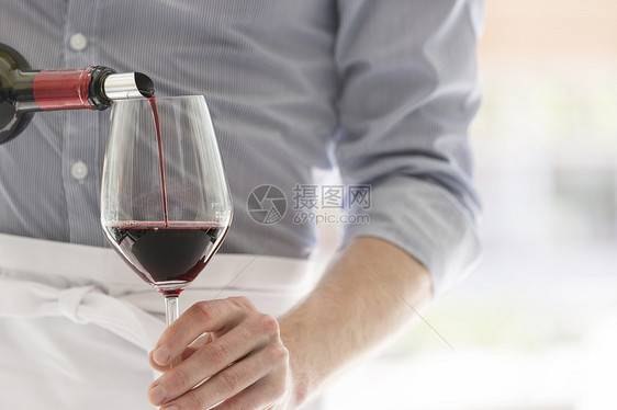 餐厅服务员酒杯里倒红酒图片
