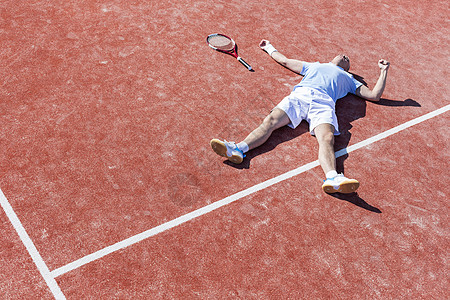 整个失望的成熟男子躺网球拍球场上夏天图片