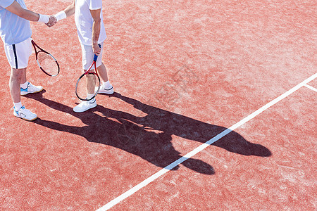 比赛期间,网球场上站着的成年男子握手的低段图片