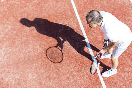 整个高年级男子夏天的周末红场打网球图片