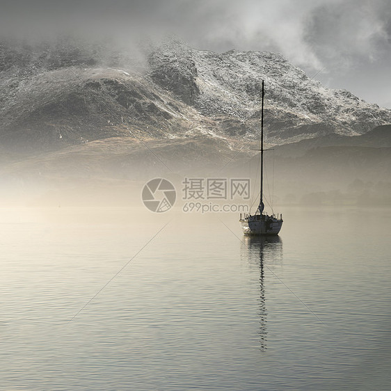 美丽的景观形象,帆船静静地坐平静的湖水中,山秋天日出的背景下隐约可见图片