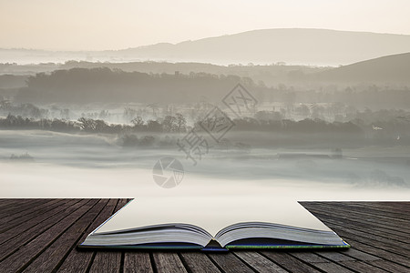 美丽的雾蒙蒙的英国乡村景观日出冬天,层层滚动田野里出来的神奇故事书页图片