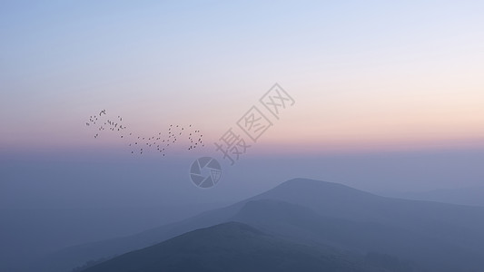 美丽的冬季日出景观形象的大岭英国的高峰地区,鸟类山峰周围飞翔图片