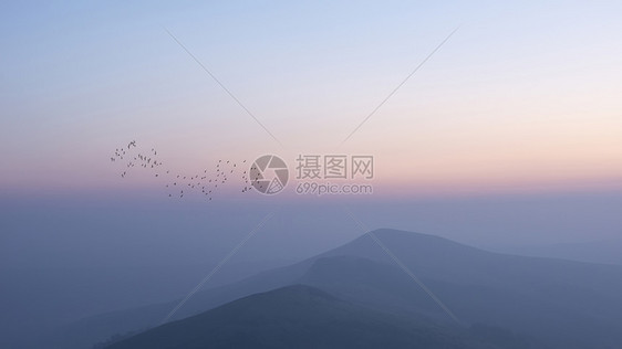 美丽的冬季日出景观形象的大岭英国的高峰地区,鸟类山峰周围飞翔图片