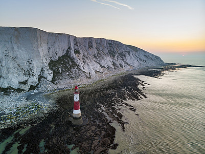 英国日出时灯塔粉笔悬崖的空中无人机景观图像图片