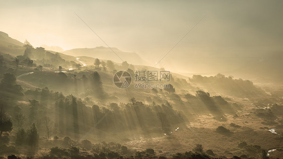 令人惊叹的秋景日出湖区,阳光透过薄雾流入朗代尔山谷图片