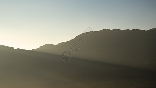 令人惊叹的秋景日出湖区,阳光透过薄雾流入朗代尔山谷图片