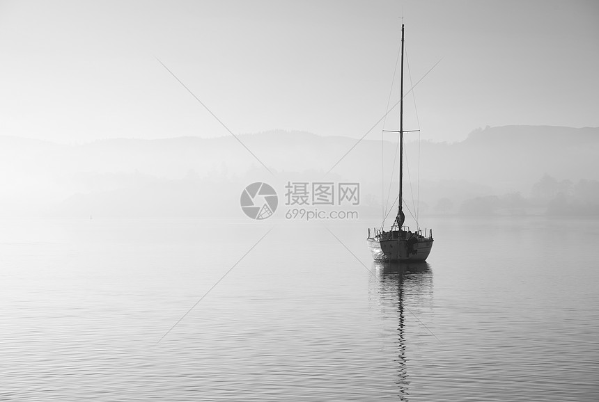 美丽的拔掉插头的景观形象,帆船坐平静的湖水中,宁静的雾蒙蒙的秋日日出图片