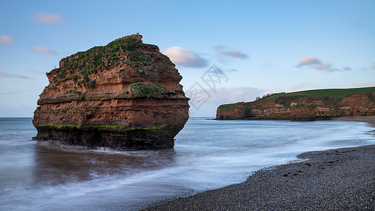 美丽的日出景观形象的拉德拉姆湾海滩德文英格兰与惊人的岩石堆海滩上背景图片