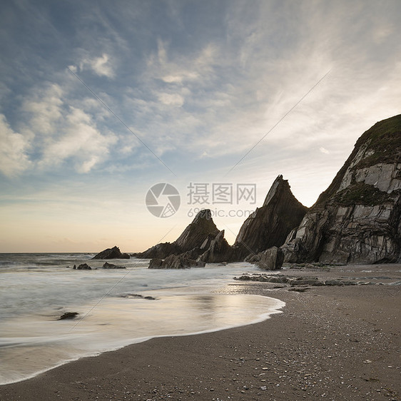 美丽的日落景观图像韦斯特康贝海滩德文英格兰与锯齿状的岩石海滩惊人的云图片