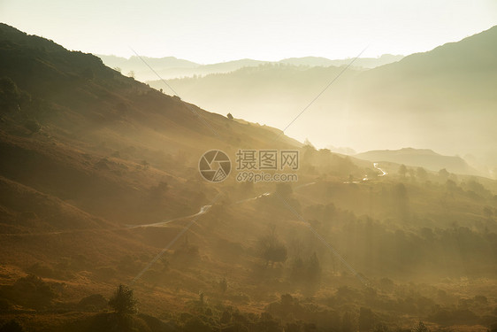 令人惊叹的秋景日出湖区,阳光透过薄雾流入朗代尔山谷图片