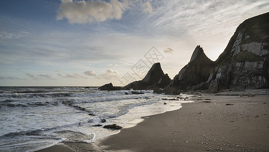 美丽的日落景观图像韦斯特康贝海滩德文英格兰与锯齿状的岩石海滩惊人的云图片