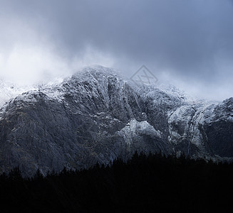 令人震惊的戏剧景观图像,白雪覆盖的格里德斯山脉雪冬期间,与威胁低云悬挂山峰图片