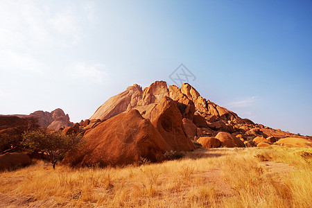 阳光明媚的炎热日子,纳米比亚山区橙色岩石的五颜六色的景观图片