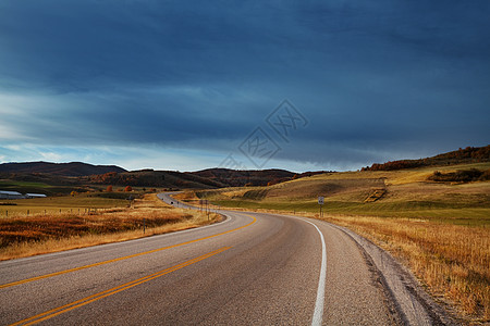 阳光明媚的早晨,乡间道路上五彩缤纷的秋天景象图片