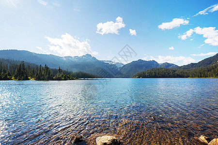 平静的景色山湖边,岩石平静的水中反射图片