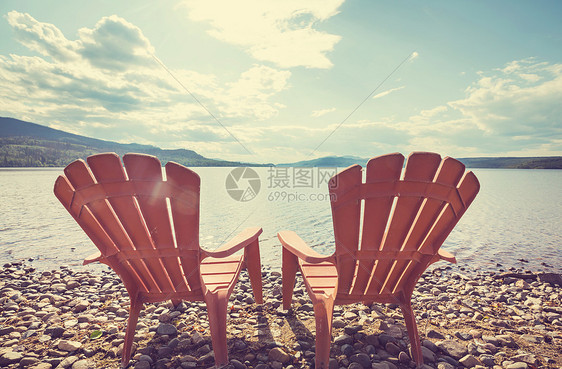 湖岸上的两把木制椅子着水图片