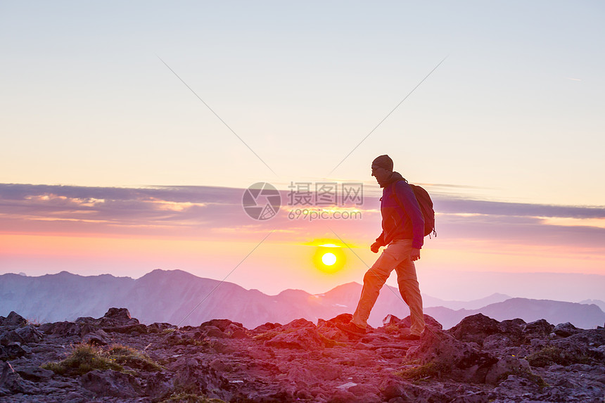 日落时美丽的夏季山脉中的徒步旅行场景图片