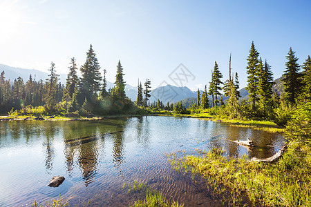 平静的景色加大的山湖旁边,岩石平静的水中反射图片