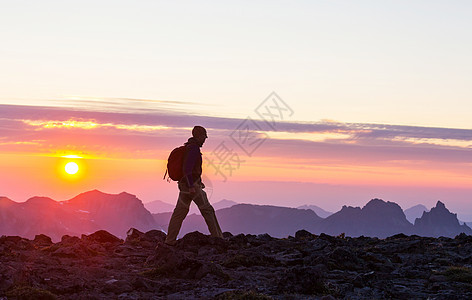 日落时美丽的夏季山脉中的徒步旅行场景图片