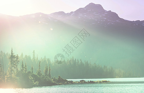 平静的景色加大的山湖旁边,岩石平静的水中反射图片