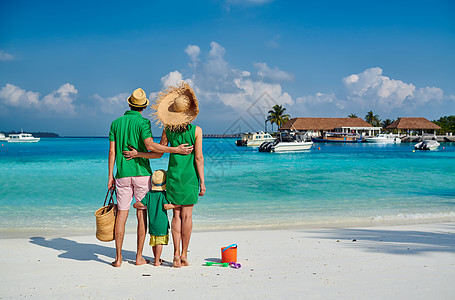 海滩上的家人,穿着绿色衣服的轻夫妇三岁的男孩马尔代夫的暑假图片