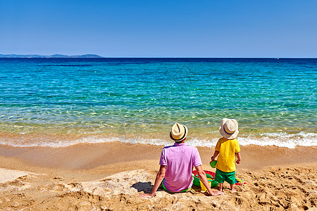 两岁的蹒跚学步的男孩父亲海滩上充气环海滩玩具暑假家庭假期希腊西索尼亚图片