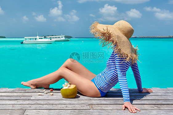 女人坐木制海滩码头上马尔代夫的暑假图片