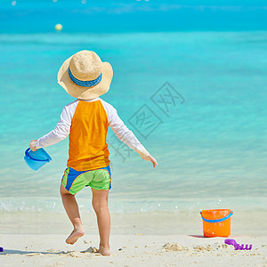 三岁的蹒跚学步的男孩海滩上玩海滩玩具马尔代夫的暑假家庭假期图片
