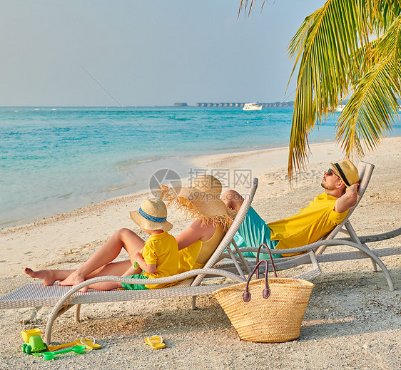 海滩上的家人,穿着黄色衣服的轻夫妇三岁的男孩马尔代夫的暑假图片