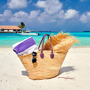 带帽子毛巾的草袋海滩上马尔代夫的暑假图片