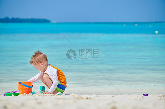 三岁的蹒跚学步的男孩海滩上玩海滩玩具马尔代夫的暑假家庭假期图片