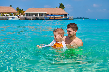 三岁的蹒跚学步的男孩学会父亲游泳马尔代夫的暑假家庭假期图片
