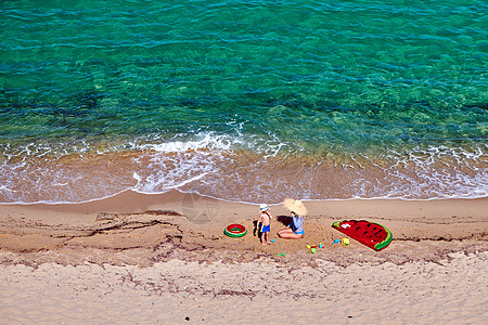 两岁的蹒跚学步的男孩他的母亲海滩上用充气浮子戒指暑假家庭假期希腊西索尼亚图片