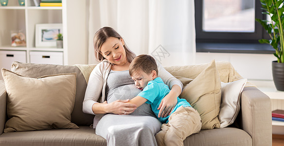 怀孕,人家庭观念快乐的怀孕母亲小儿子拥抱家里快乐怀孕的母子拥抱家里图片