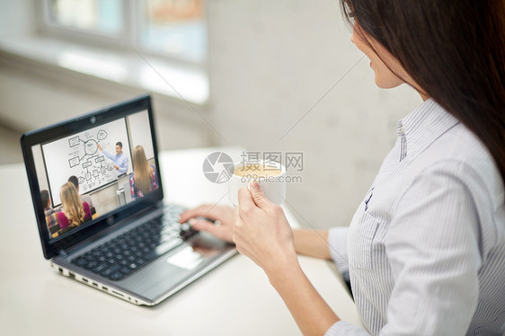 商业,教育技术妇女喝咖啡观看网络研讨会上的笔记本电脑办公室咖啡的女人笔记本电脑上看网络研讨会图片