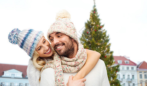 寒假幸福的夫妇戴着帽子拥抱诞树塔林老市政厅广场背景幸福的夫妇拥抱诞树上图片