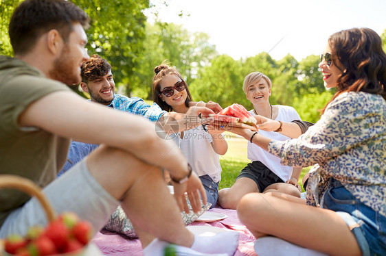 友谊休闲食物群快乐的朋友夏季公园野餐时分享西瓜快乐的朋友夏天野餐时分享西瓜图片