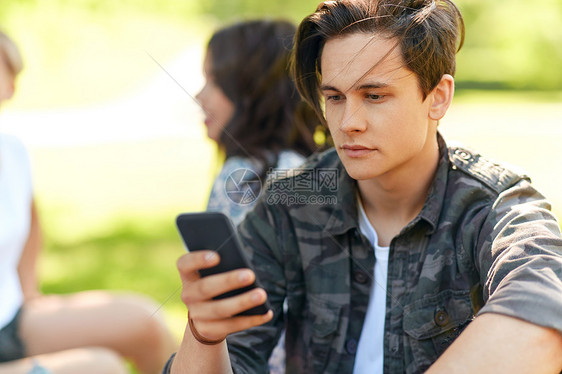 休闲,技术人的女人用智能手机与朋友夏季公园男人夏天公园朋友用智能手机图片