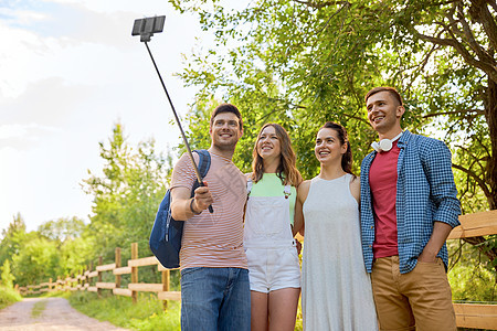 技术,友谊徒步旅行群微笑的朋友夏天用智能手机自拍杆上拍照朋友们用智能手机自拍杆上拍照图片