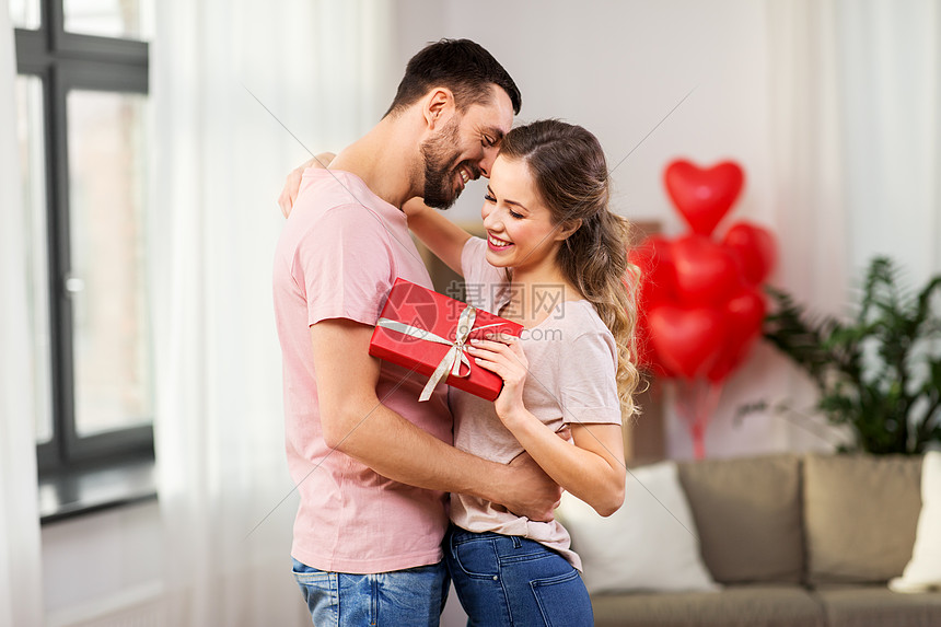 情人节,关系人的幸福的夫妇与礼品盒拥抱家里幸福的夫妇家里抱着礼品盒图片
