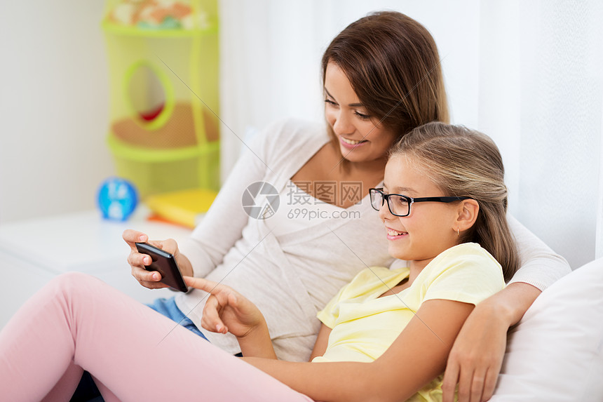 人,家庭技术快乐的母亲女儿家里智能手机快乐的母亲女儿家里智能手机图片