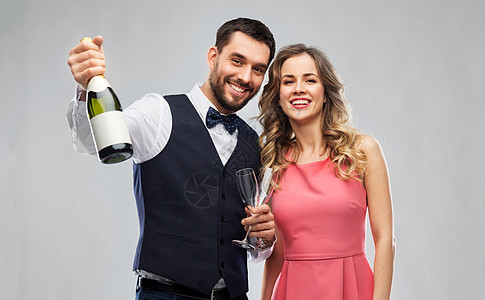 庆祝人们的幸福的夫妇与瓶香槟眼镜灰色背景幸福的夫妇带着瓶香槟眼镜图片