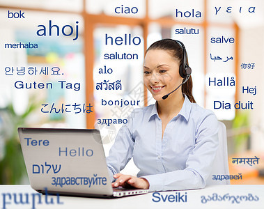 翻译,商业技术微笑的女翻译操作员与电脑办公室用同的外语问候词笔记本电脑的女人超过了外语的单词图片