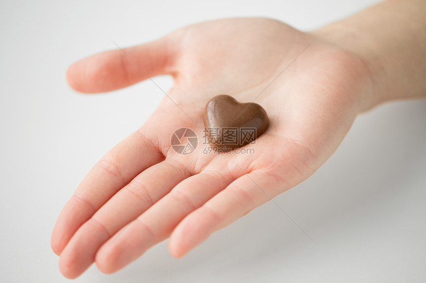 情人节,糖果糖果的近距离的手心形巧克力糖果用心形巧克力糖果靠近手图片