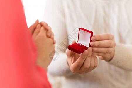 情人节,求婚订婚的男人小红色礼品盒里给家里的女人送钻石戒指情人节男人给女人钻石戒指图片