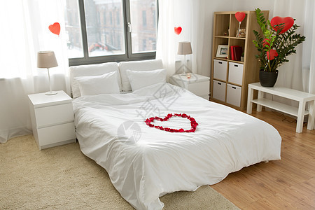 情人节,浪漫的约会假期床装饰的心由红色花瓣卧室家里舒适的卧室装饰情人节图片